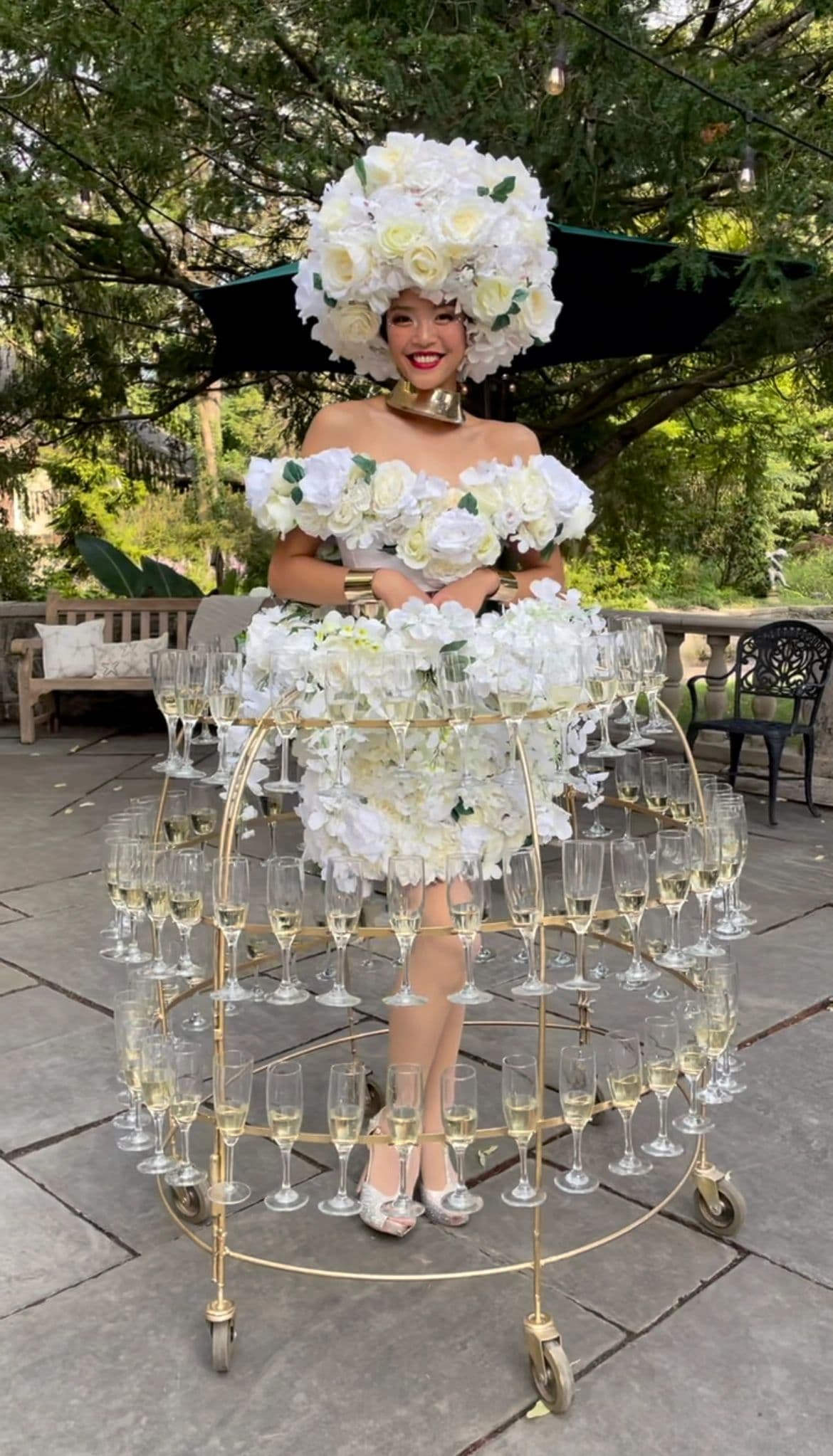 Champagne dress diva in a floral white gown serving champagne at a luxury wedding reception
