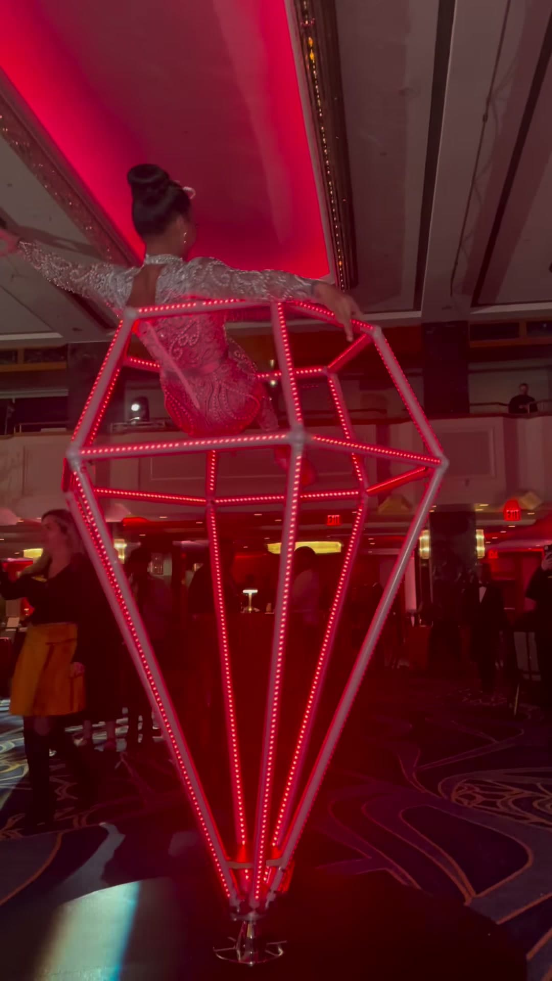 Aerialist suspended inside a giant red LED diamond apparatus at a New York City corporate event