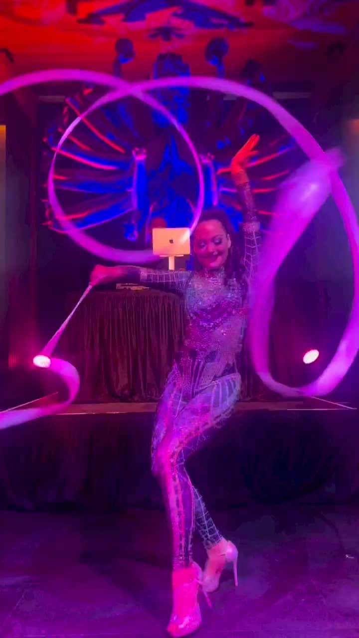 Rhythmic gymnast performer twirling ribbons on a stage at a New York City corporate event