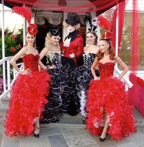 Showgirl greeter in feathered headdress welcoming guests at a luxury reception