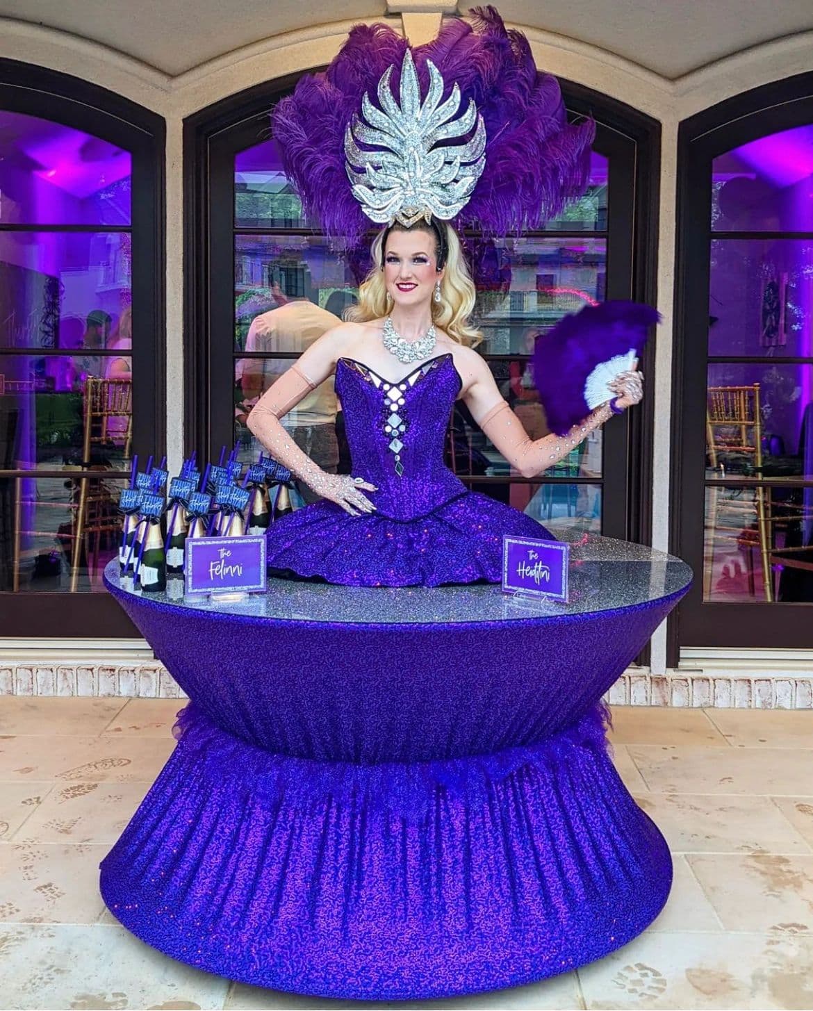 Strolling table performer in a purple gown serving canapes at a luxury cocktail reception