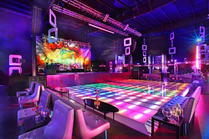 Multicolour LED checkered dance floor lit up in a lounge-ringed ballroom by Nicholson Events