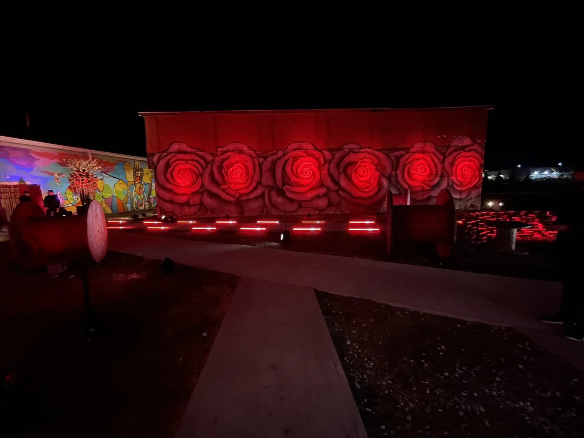 Outdoor evening event with red uplighting and string lights