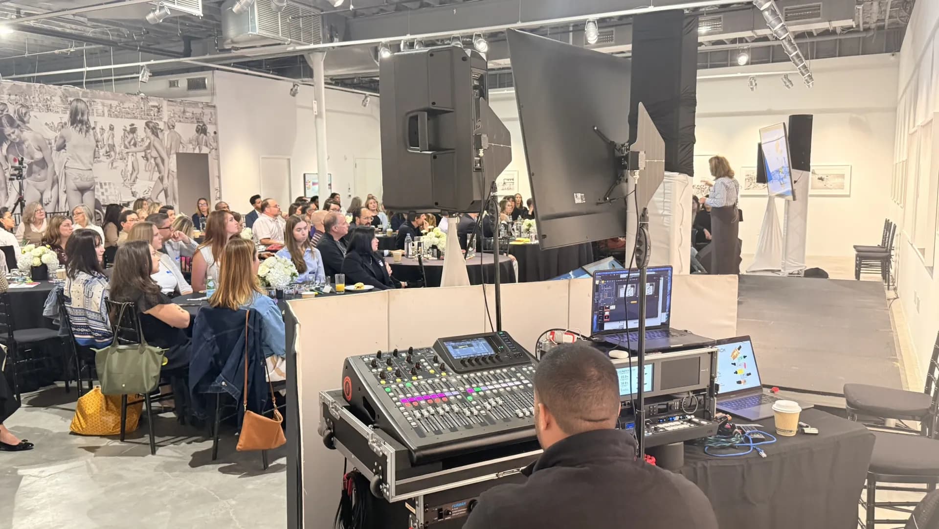 Sound engineer at a digital mixing console with line-array speakers