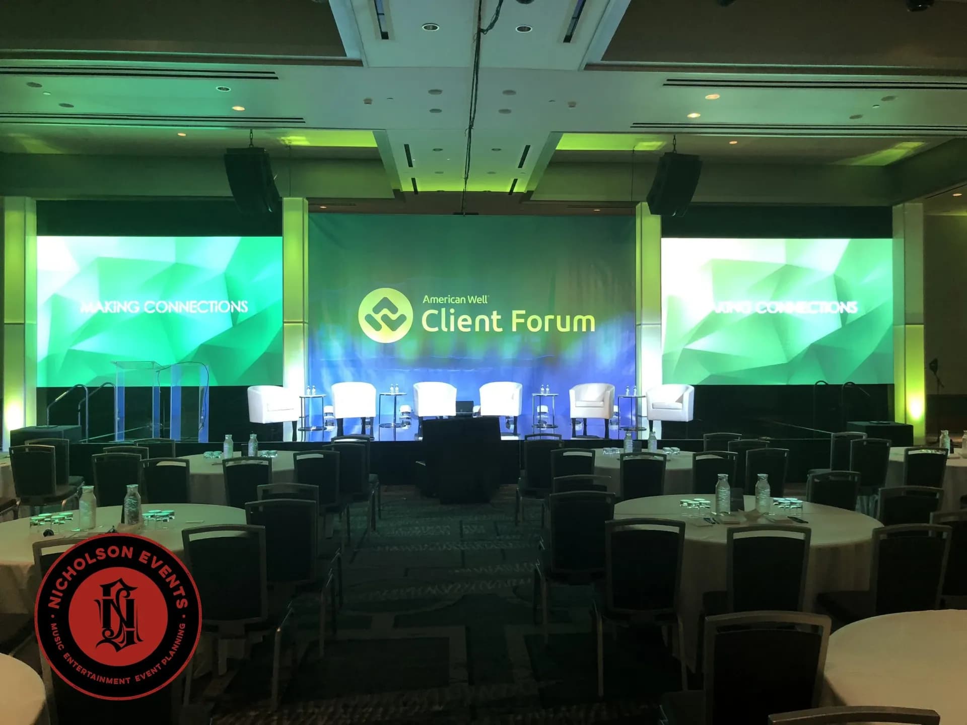 Corporate conference stage with LED screens and seating