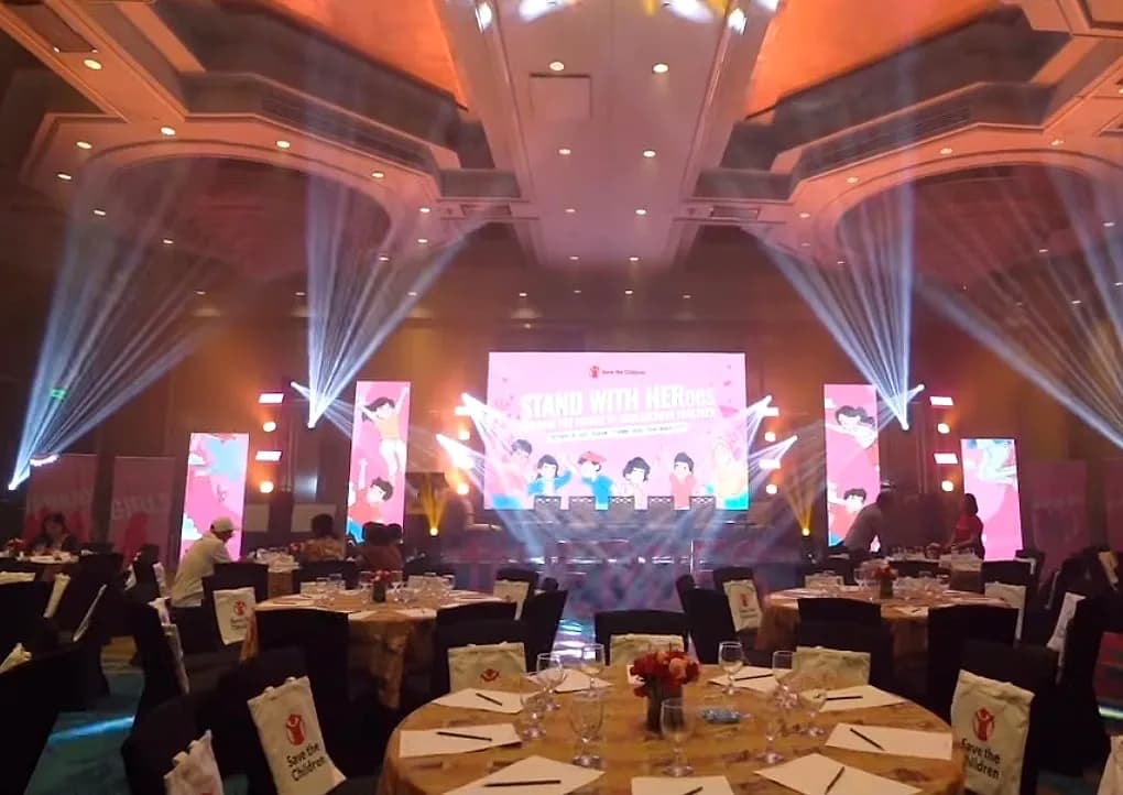 Gala stage design with LED screens, branded banners, and beam lighting in a hotel ballroom produced by Nicholson Events