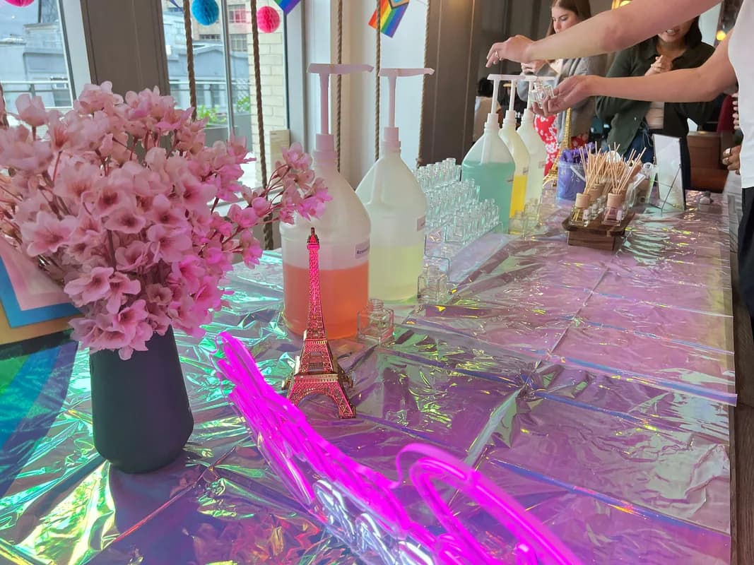 Guests hand-mixing fragrance oils and filling reed diffuser bottles at an aroma reeds station