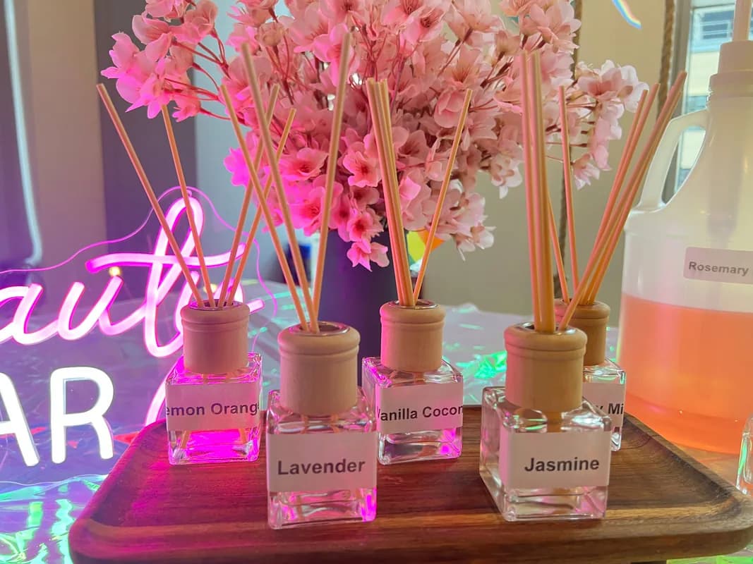 Finished reed diffuser bottles labeled with scent names like lavender, jasmine, and vanilla coconut at an aroma reeds station
