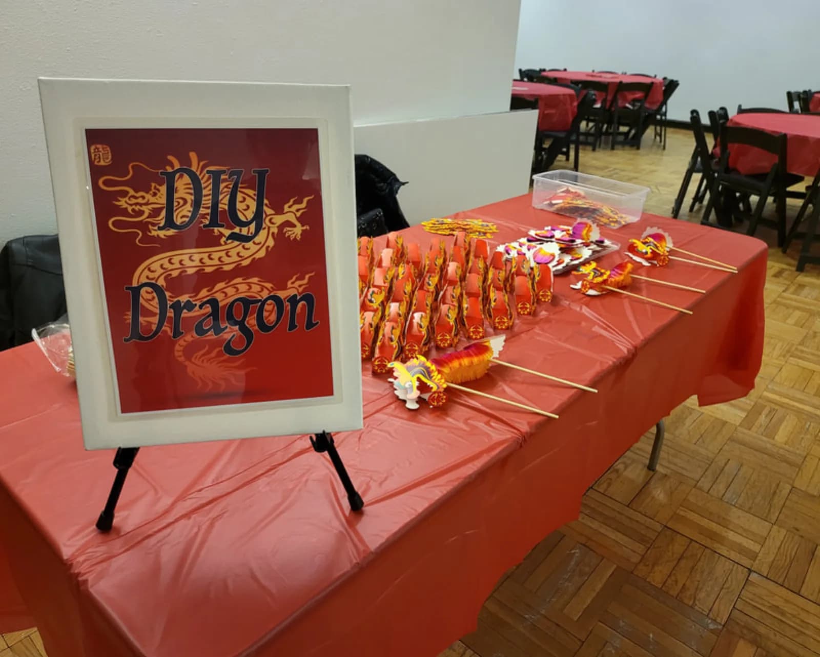 Build a Dragon craft station display with finished paper dragons on wooden sticks and a DIY Dragon sign at an event