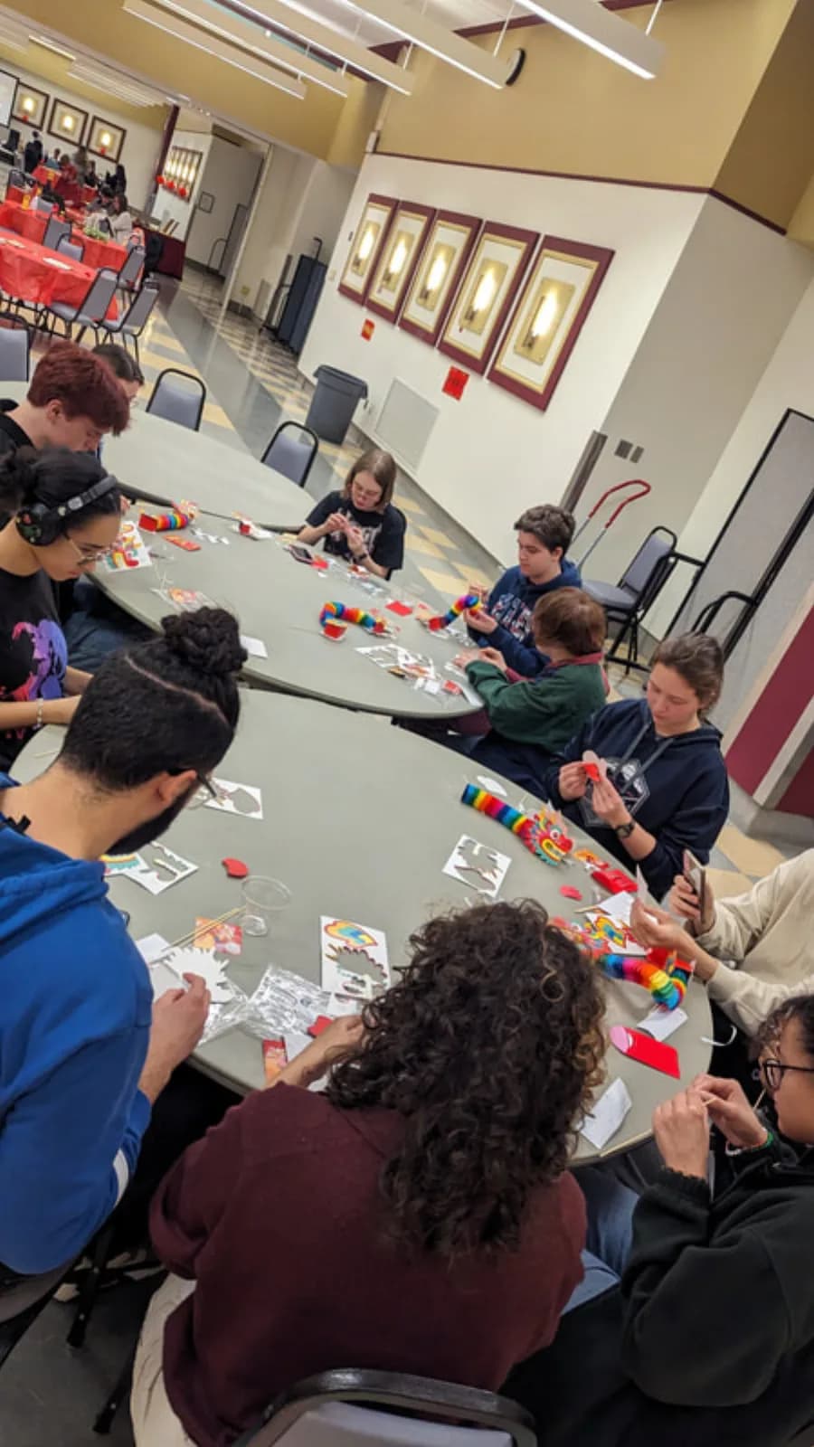 Guests assembling colorful dragon crafts together at a build a dragon station table