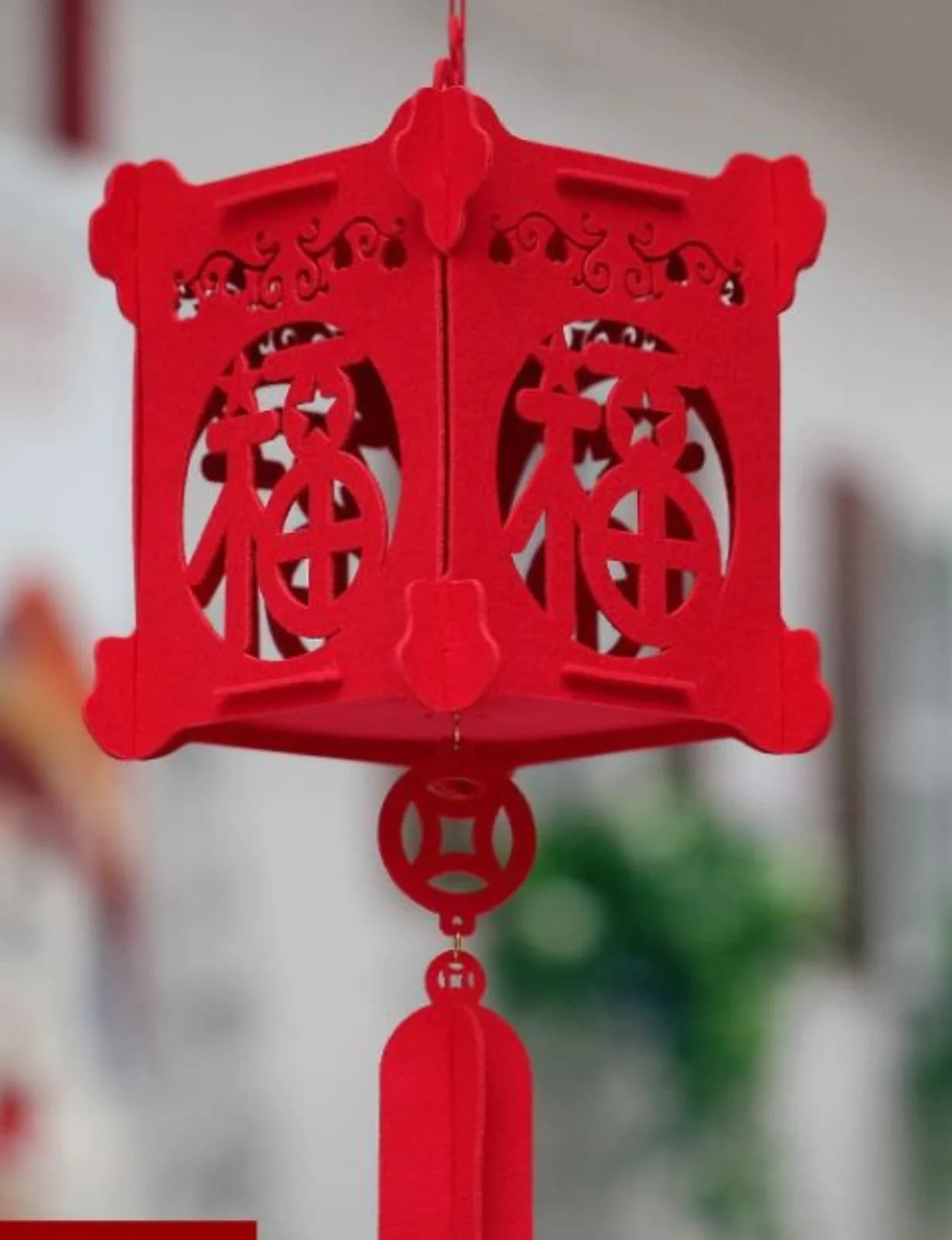 Finished red lantern craft hanging with a tassel detail, a keepsake from the build a lantern station