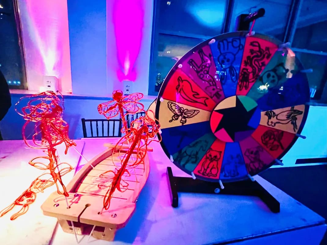 Candy sculpture station display with a spin-to-win prize wheel at an event venue