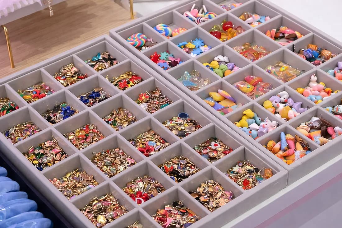 Trays of colorful charms and gems guests choose from to decorate their claw clip at the station
