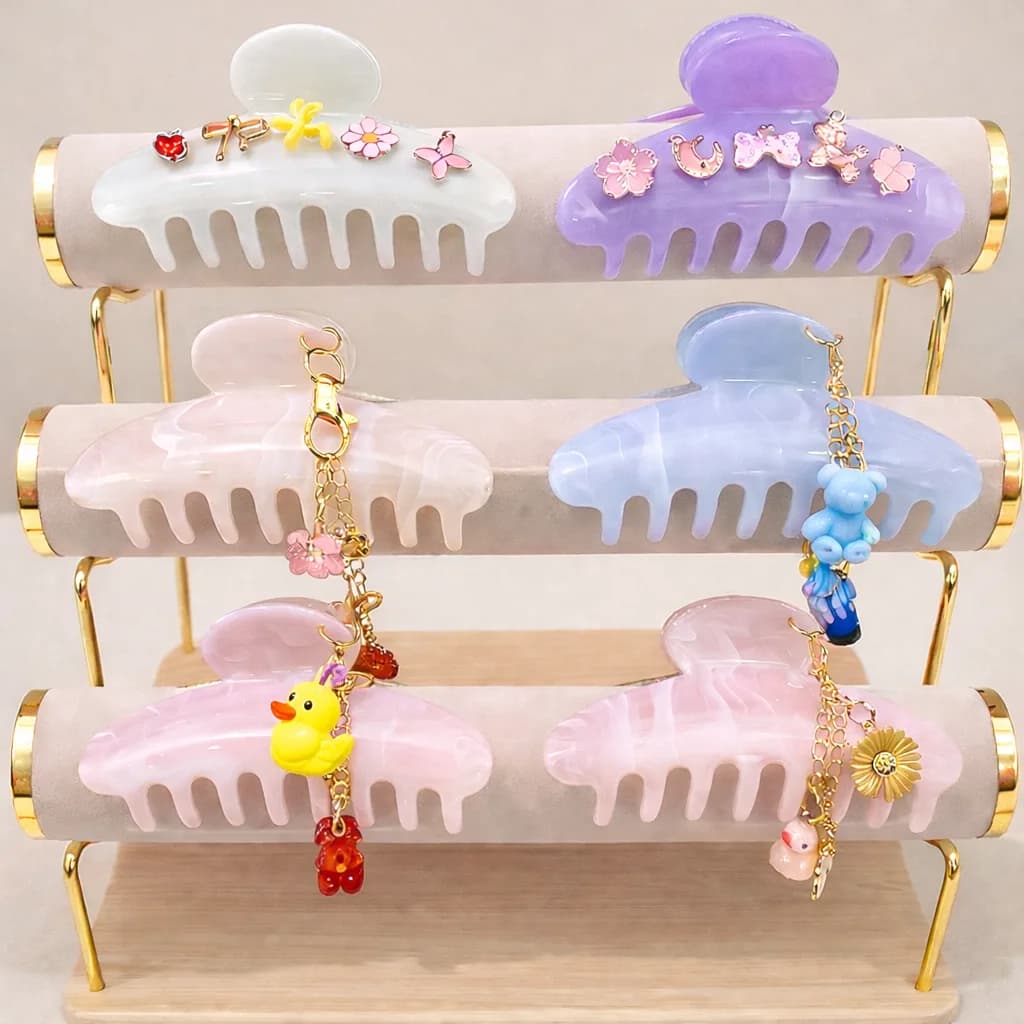 Tiered display of pastel claw clips with dangling charm keychains at an event claw clips bar station