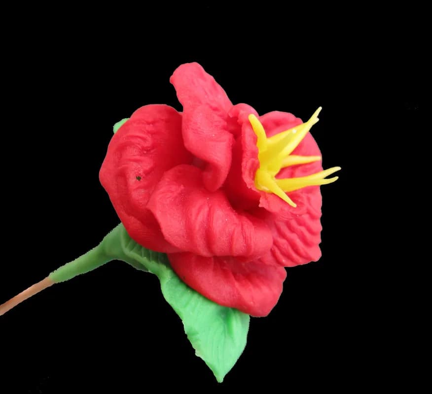 Handmade clay rose sculpture in red and green, a finished piece from the clay sculptures station