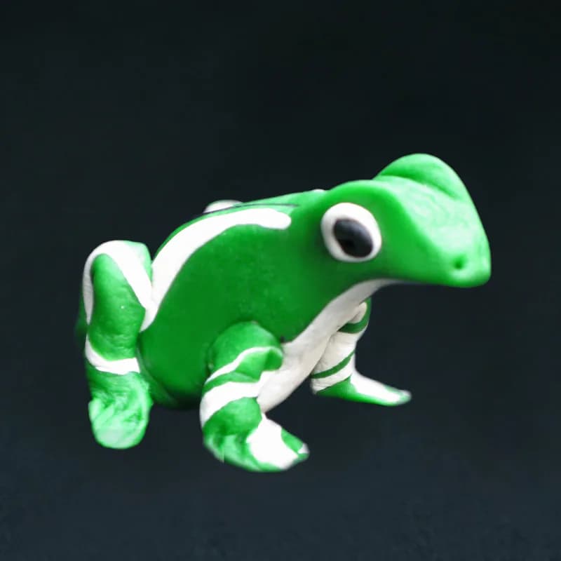 Handmade clay frog sculpture in green and white, a finished piece from the clay sculptures station