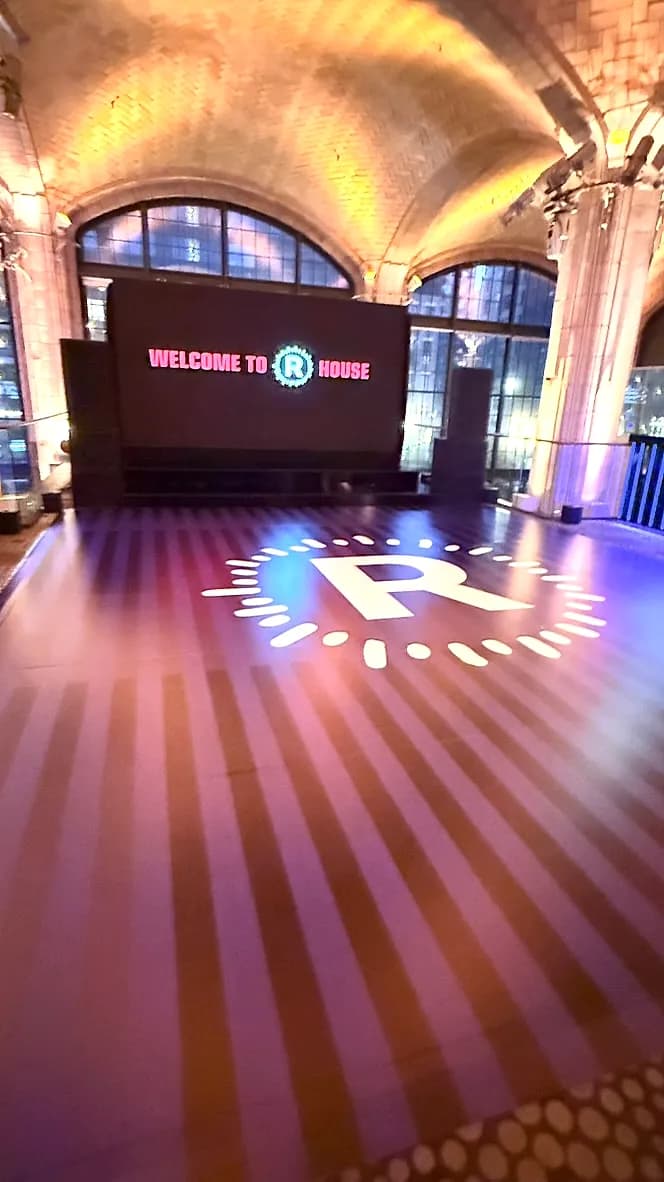Full custom dance floor wrap with a circular monogram logo projected at center inside a vaulted historic NYC venue produced by Nicholson Events