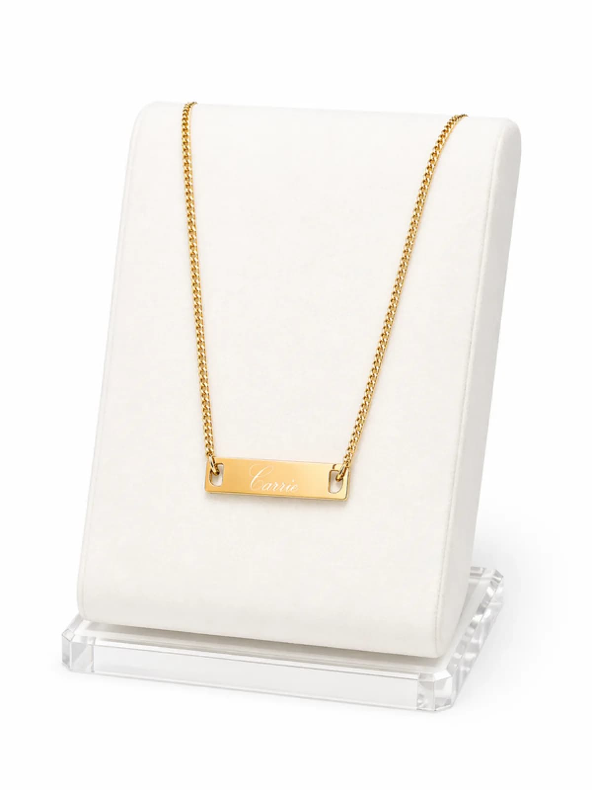 Gold bar necklace engraved with a name displayed on a jewelry stand from an engraving station