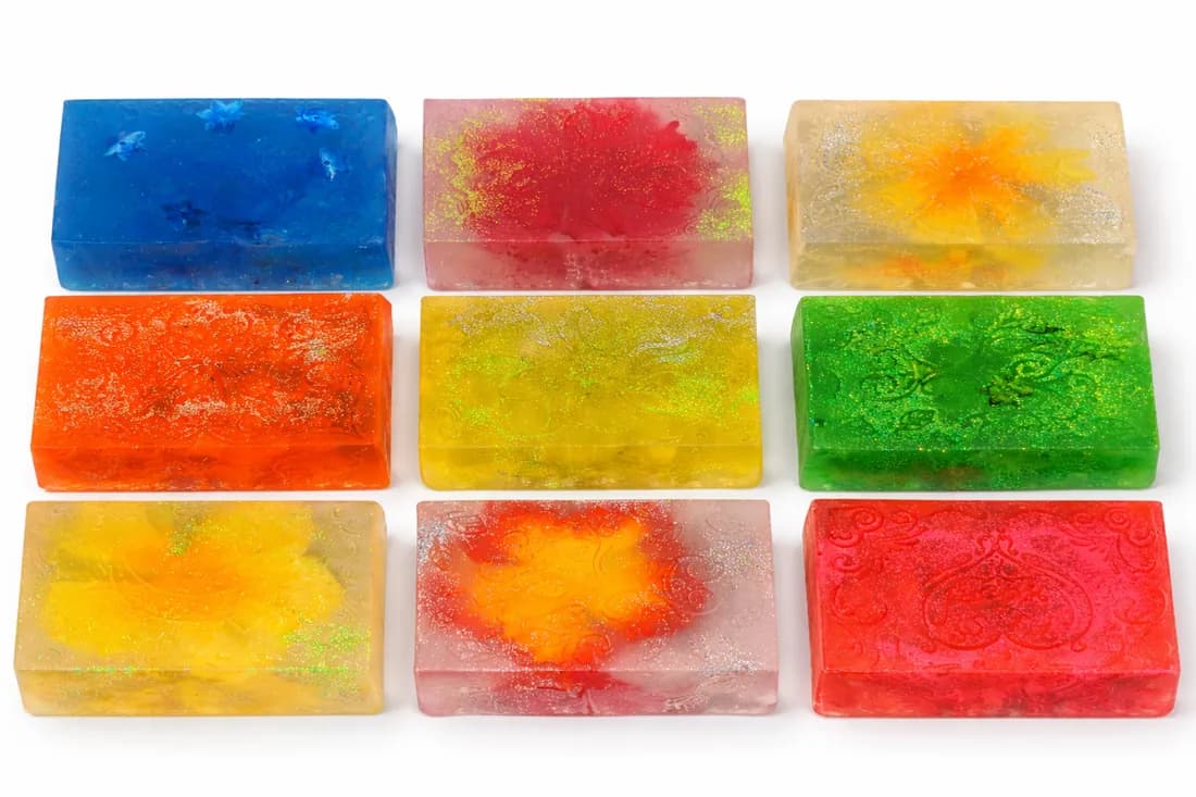Colorful marbled glycerin soap bars in blue, red, yellow, and green at a custom soap making station