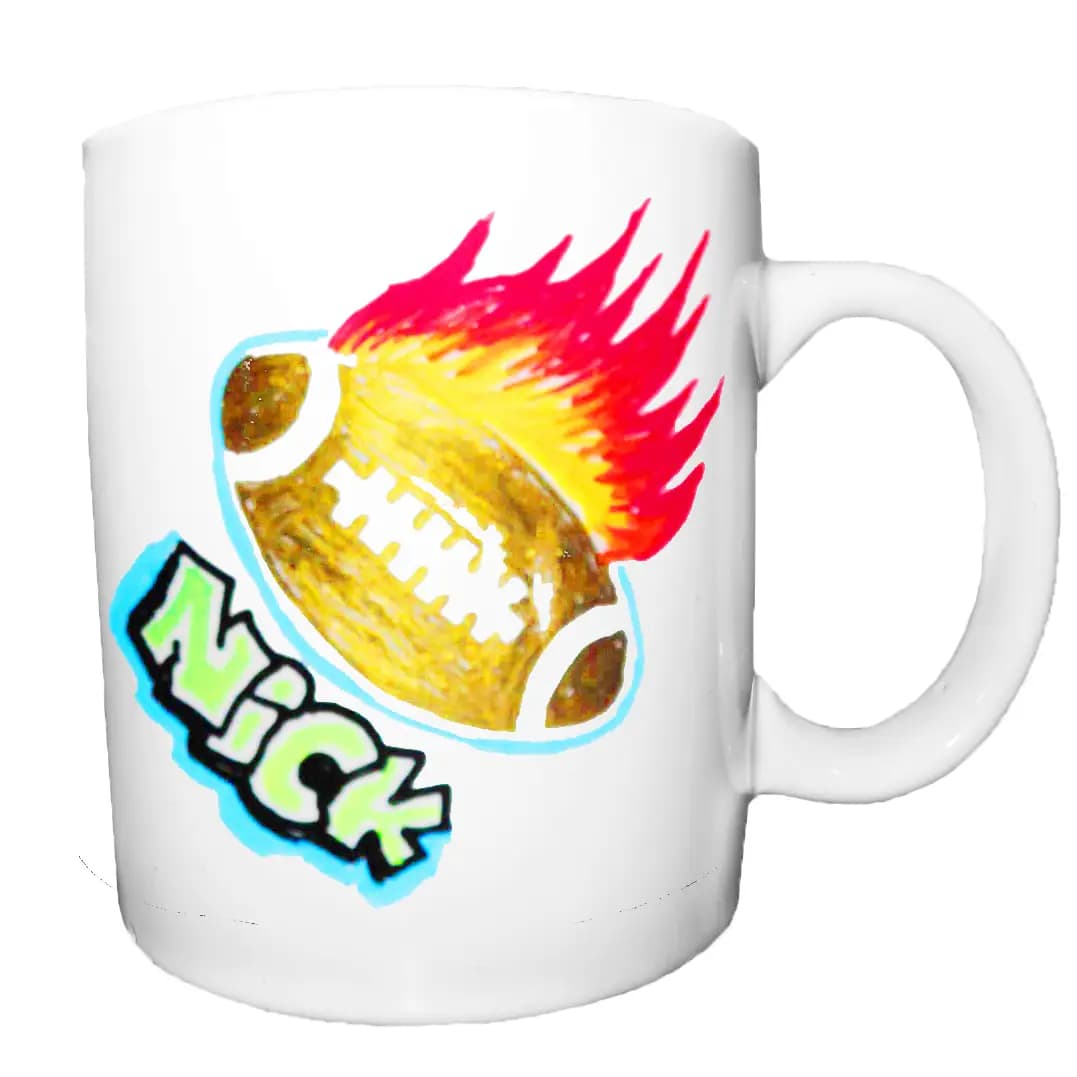 Clear glass mug hand-decorated with a marker drawing of a flaming football and the name Nick, a keepsake from the marker art station