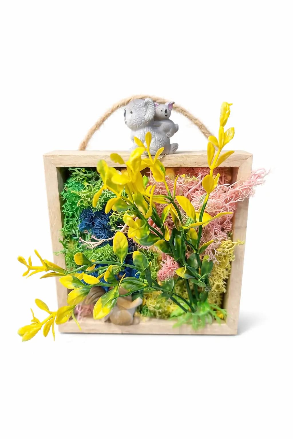 Framed moss wall art piece with green, blue, pink, and yellow preserved moss, a koala figurine, and artificial yellow flowers, a keepsake from the moss wall art station