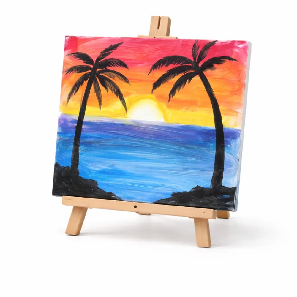 Guided painting workshop station with finished canvases at a party