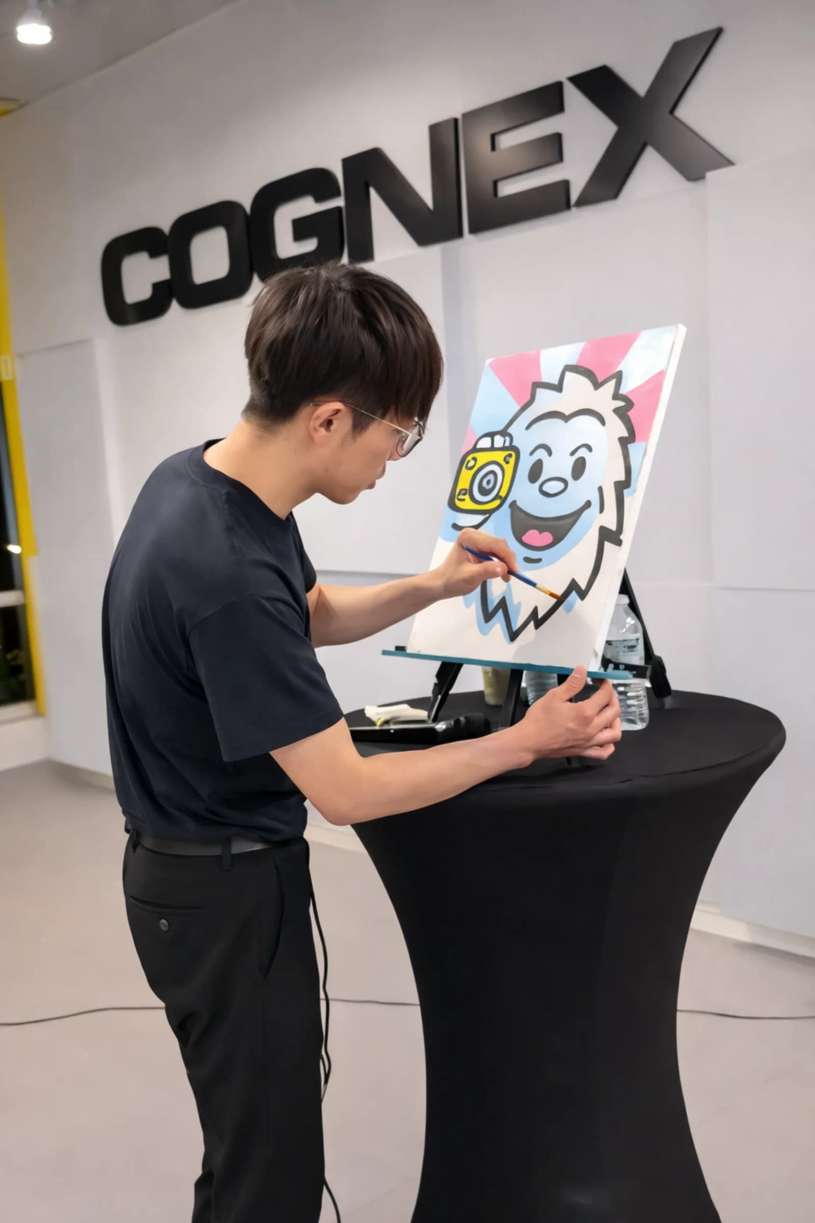 Guest carefully painting a cartoon character canvas at an indoor guided painting workshop