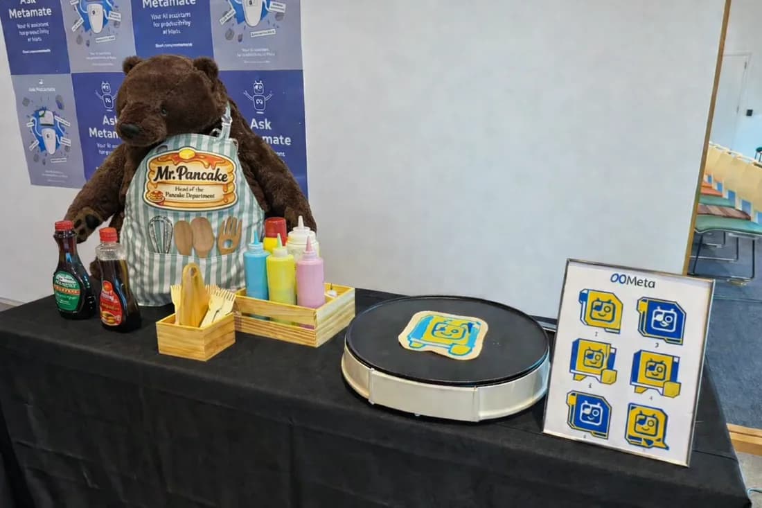Branded corporate pancake art station with a plush mascot, syrups, and a custom logo design on the griddle