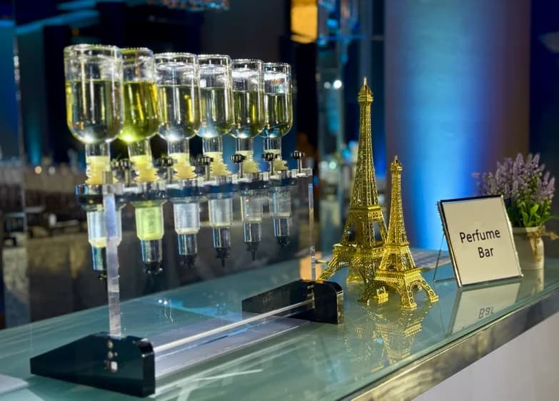 Perfume Bar signage next to fragrance dispensers and gold Eiffel Tower decor at an elegant evening event