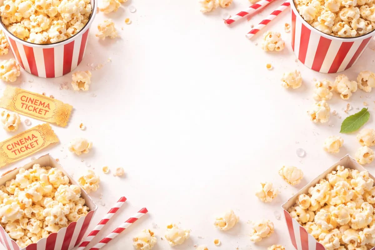Popcorn buckets, boxes, and striped straws arranged with cinema tickets at an event popcorn station
