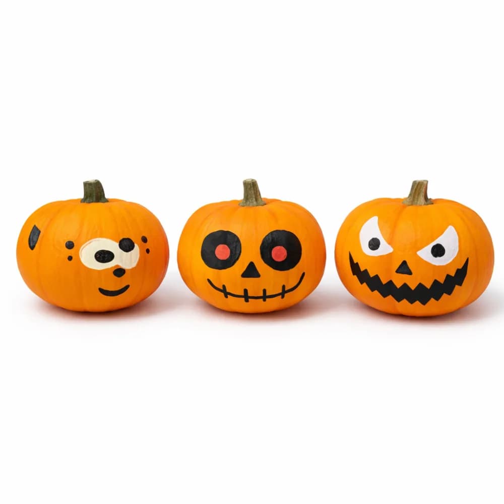 Three mini pumpkins hand-painted with playful jack-o-lantern faces from a pumpkin painting station