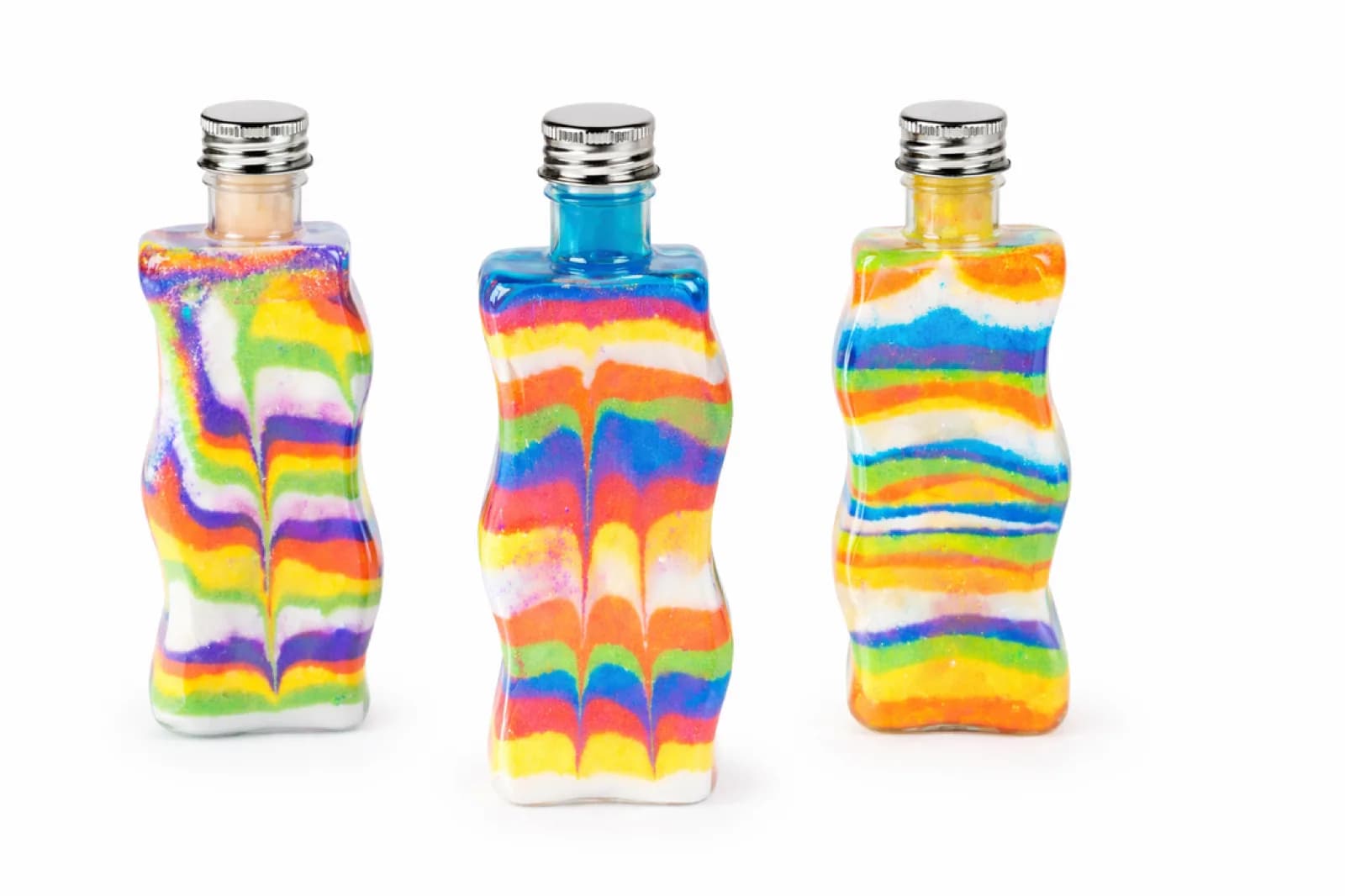 Three wavy glass bottles filled with rainbow layered sand at a sand art station