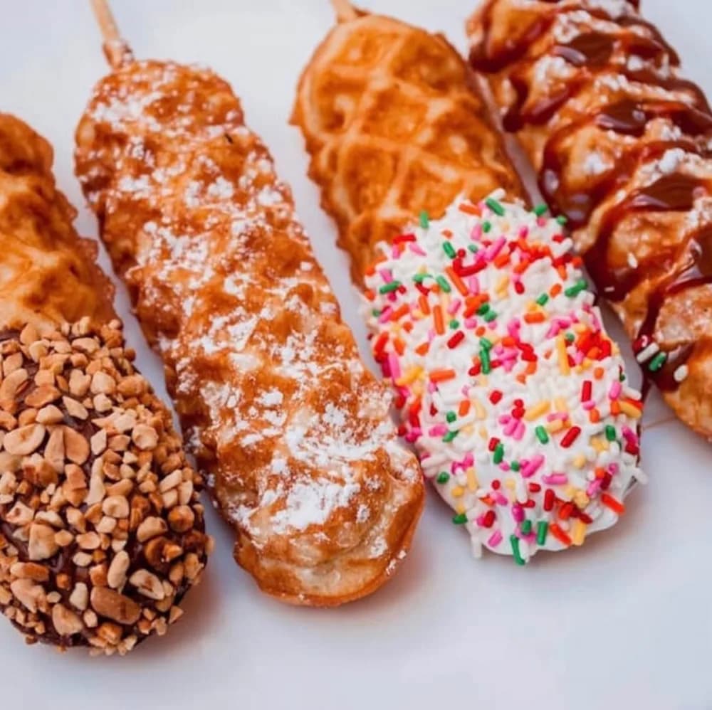 Waffle sticks station with warm dipped waffles and toppings at an event food station