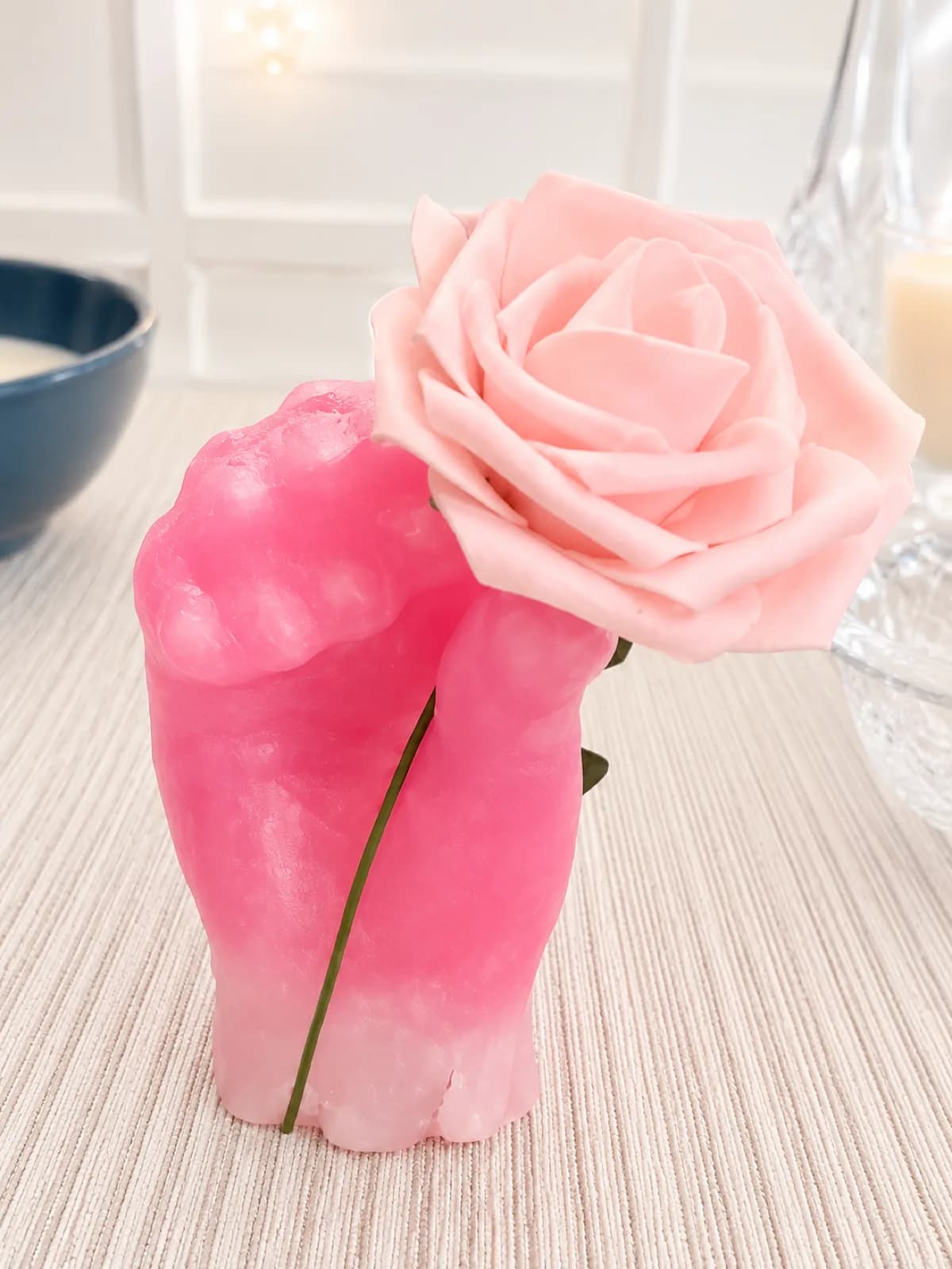 Pink ombre wax hand cast holding a single rose, a keepsake from the wax hands station