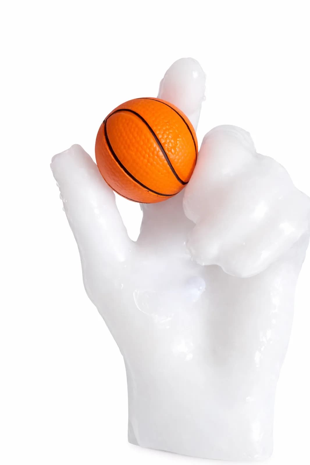 White wax hand cast holding a mini basketball between two fingers at a wax hands station