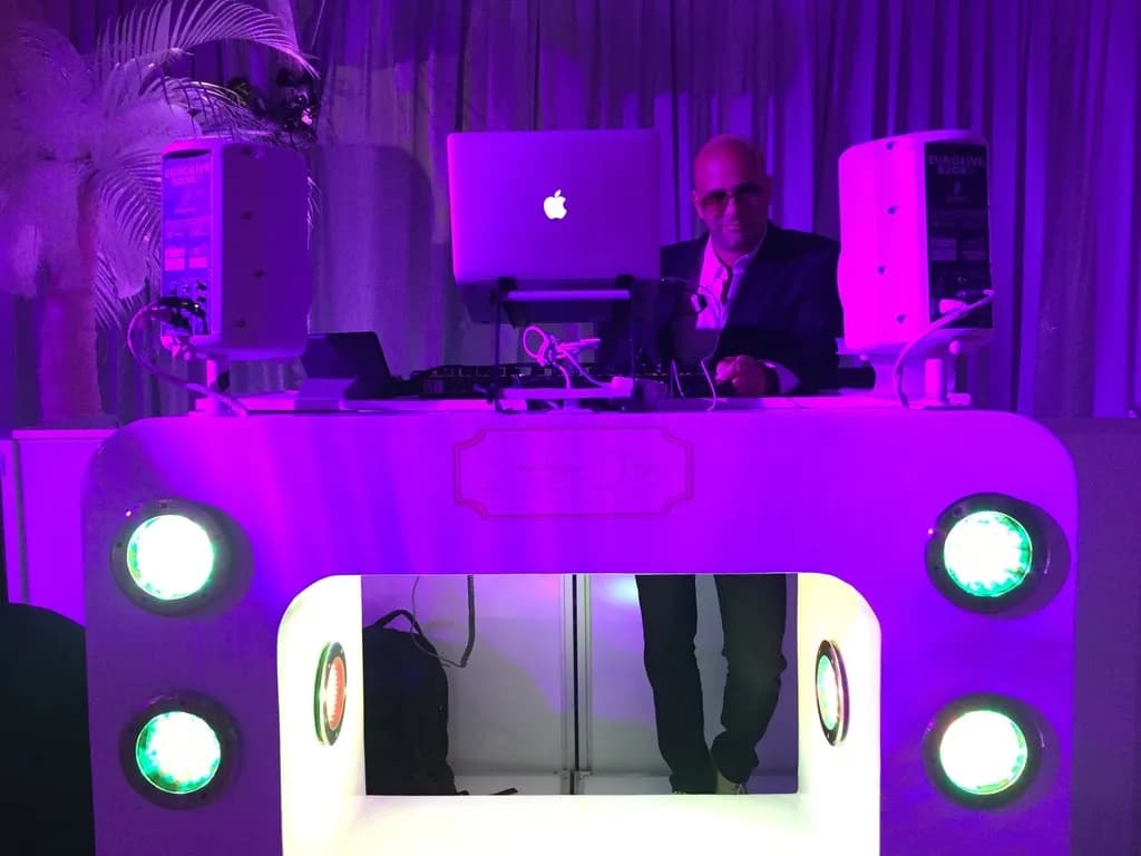 Custom white LED DJ booth with purple uplighting at a sweet 16 celebration