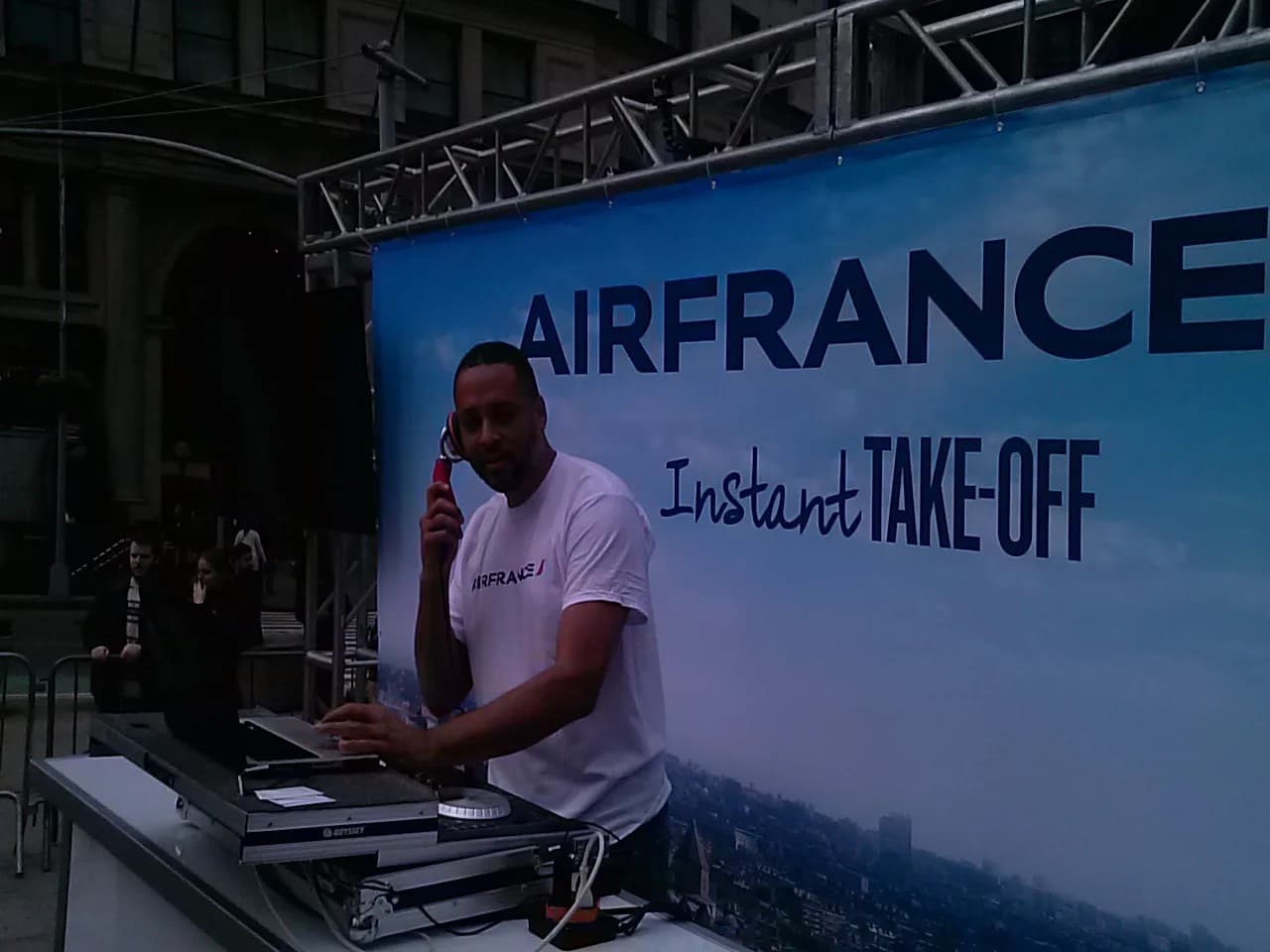 DJ David Raimer spinning at an Air France outdoor brand activation in New York City, headphones to one ear