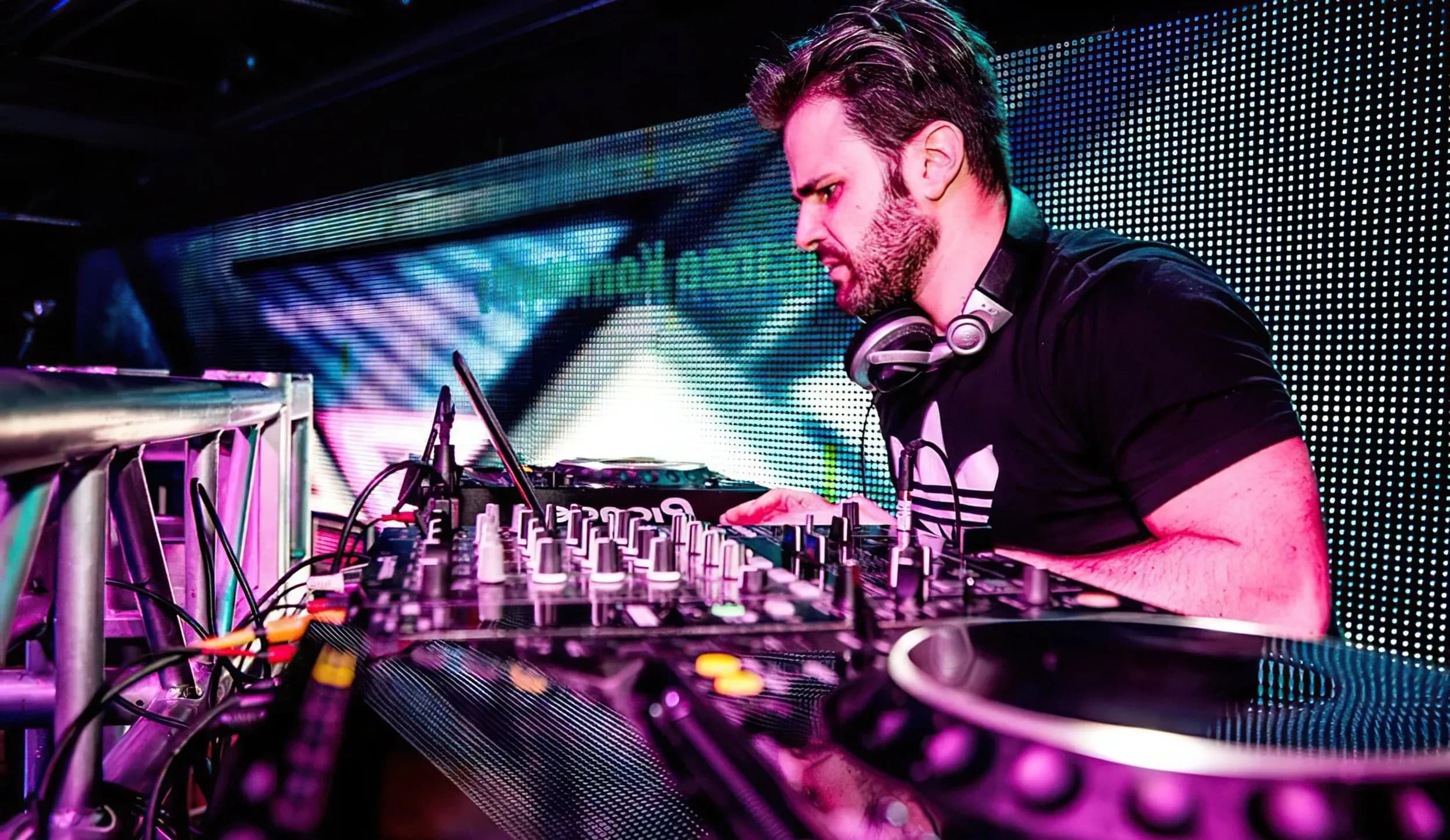 DJ and MC Gabriel at the decks in front of an LED wall on a production stage