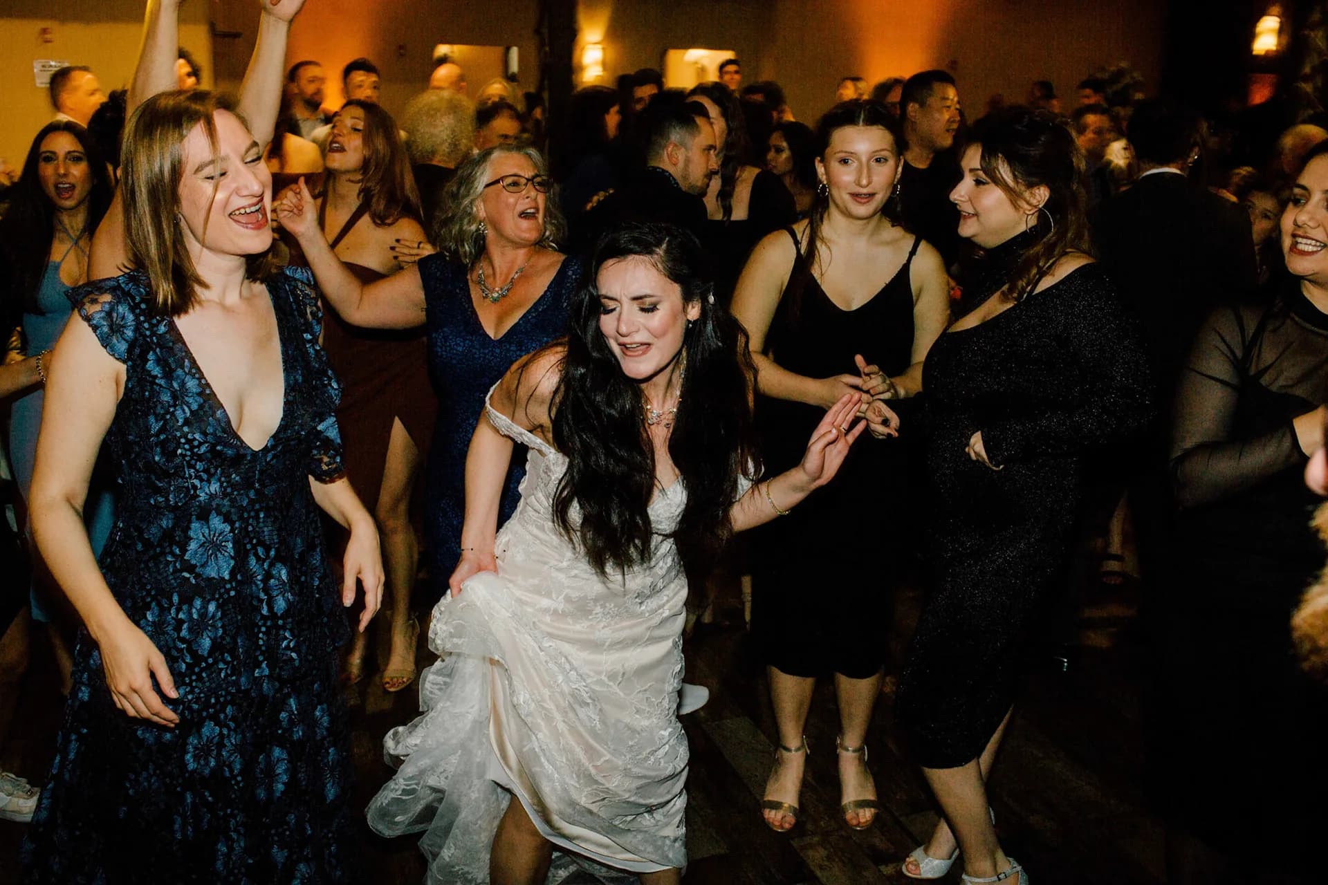 Elegantly dressed guests dancing together at a formal black-tie celebration
