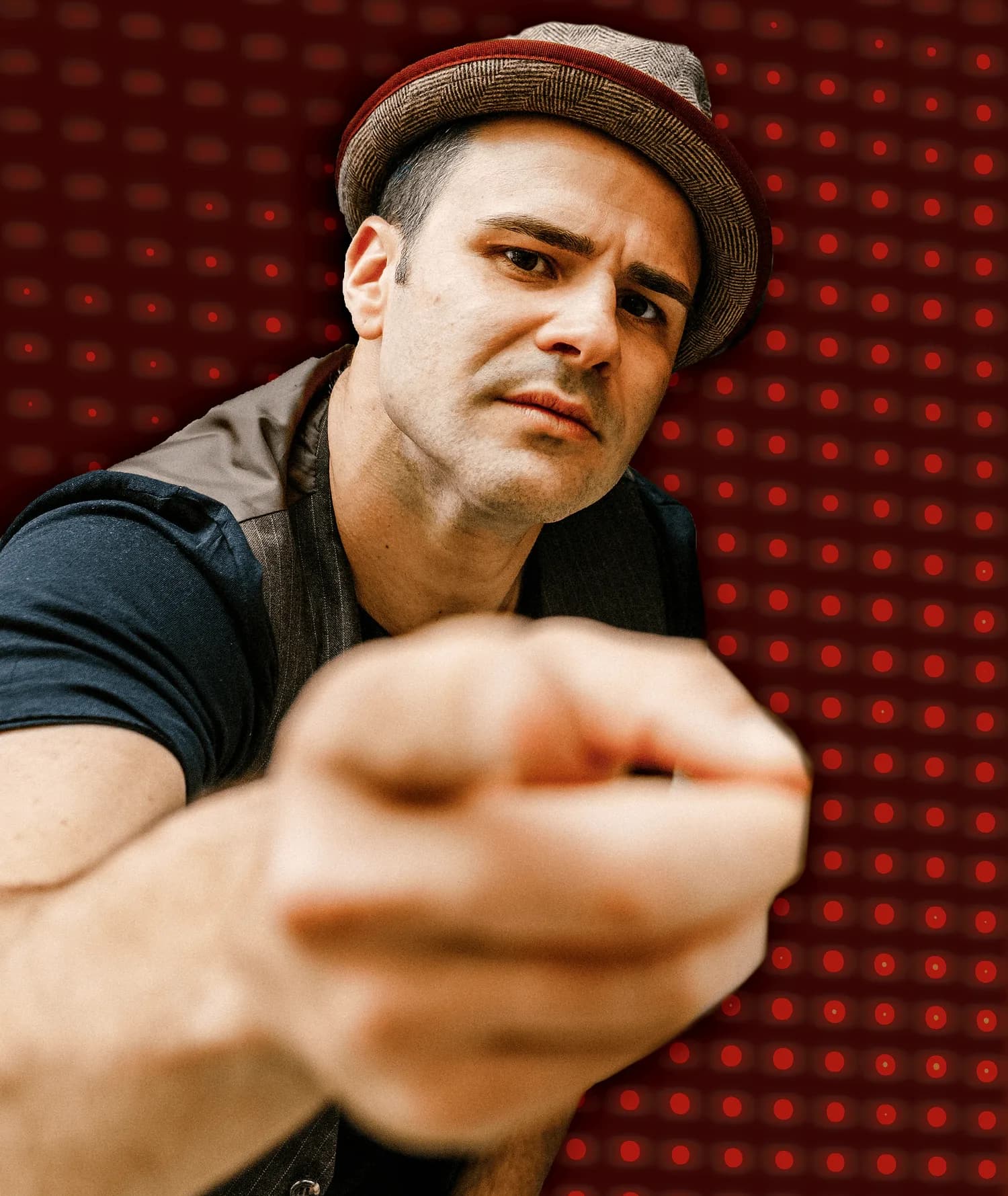 Gabriel, DJ and MC, in a close-up editorial portrait against a red lit stage backdrop
