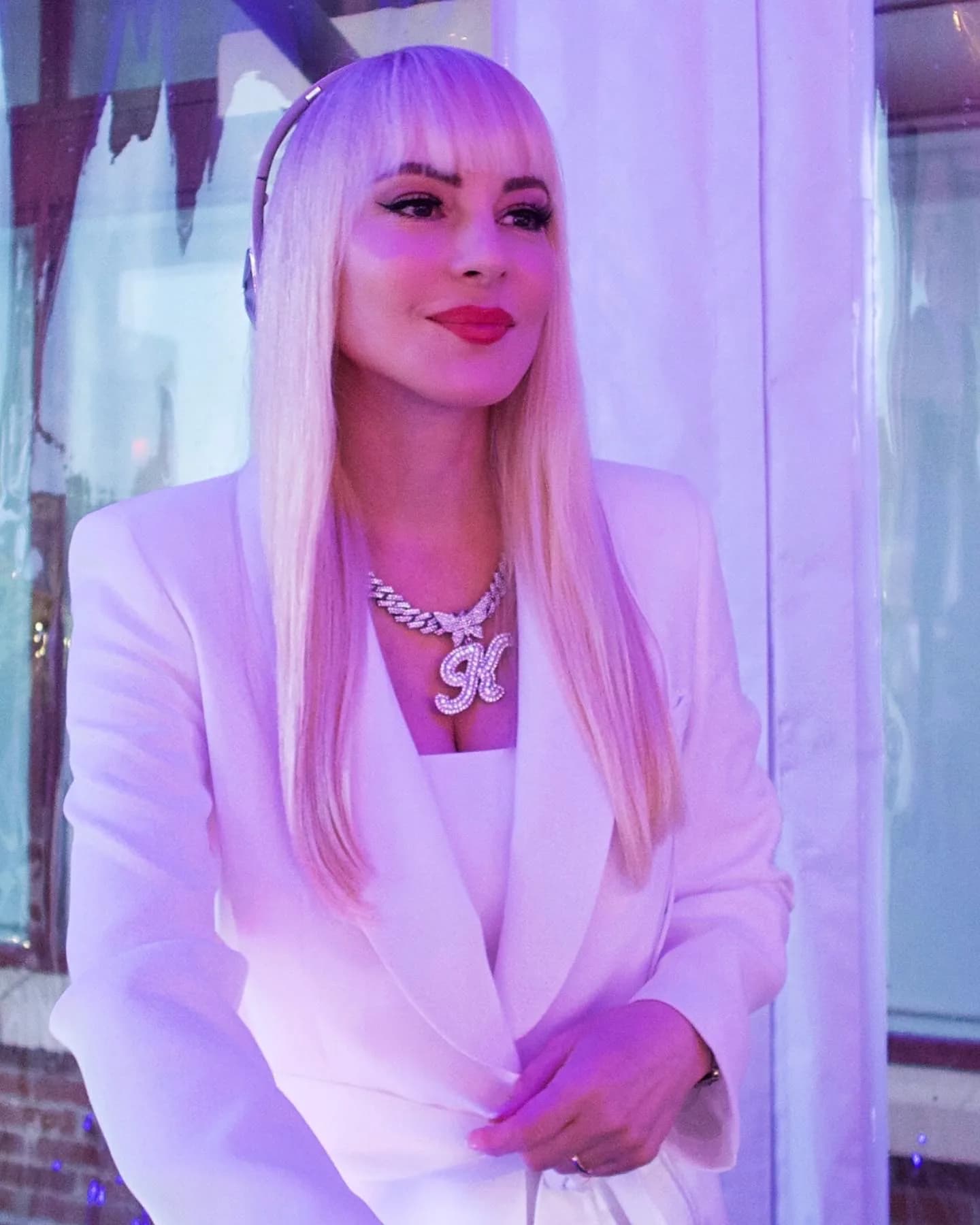 DJ Kristaval close-up portrait in a white blazer and headphones, the in-demand NYC female event DJ