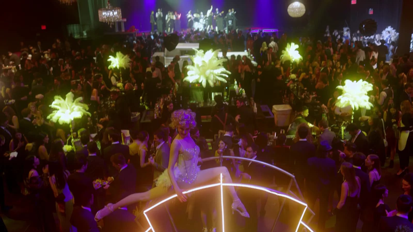 DJ Kristaval promo reel poster: a full-production gala with gold feather displays and a packed room