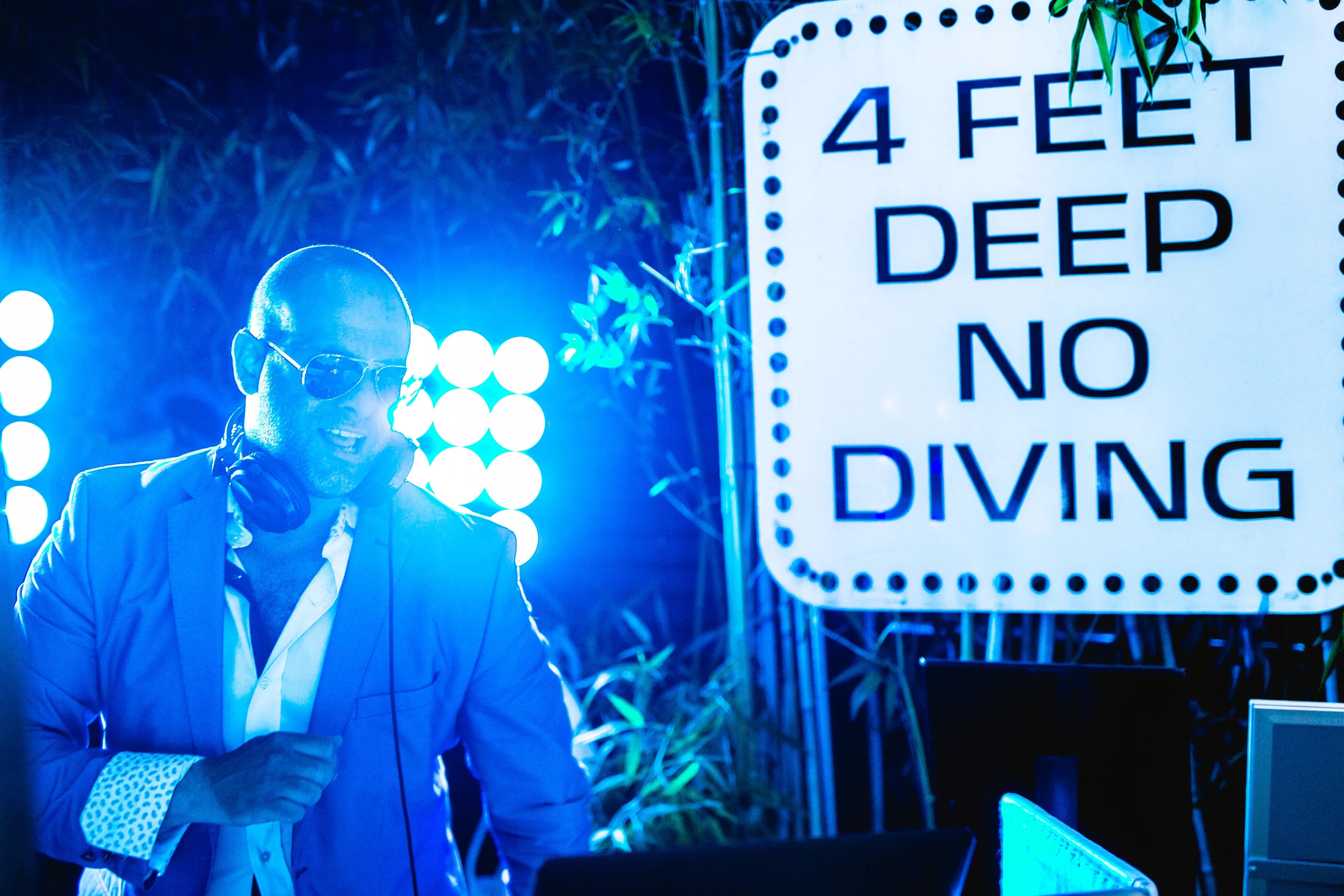 Shiran Nicholson in a blue jacket at the decks in atmospheric blue stage haze at a private event