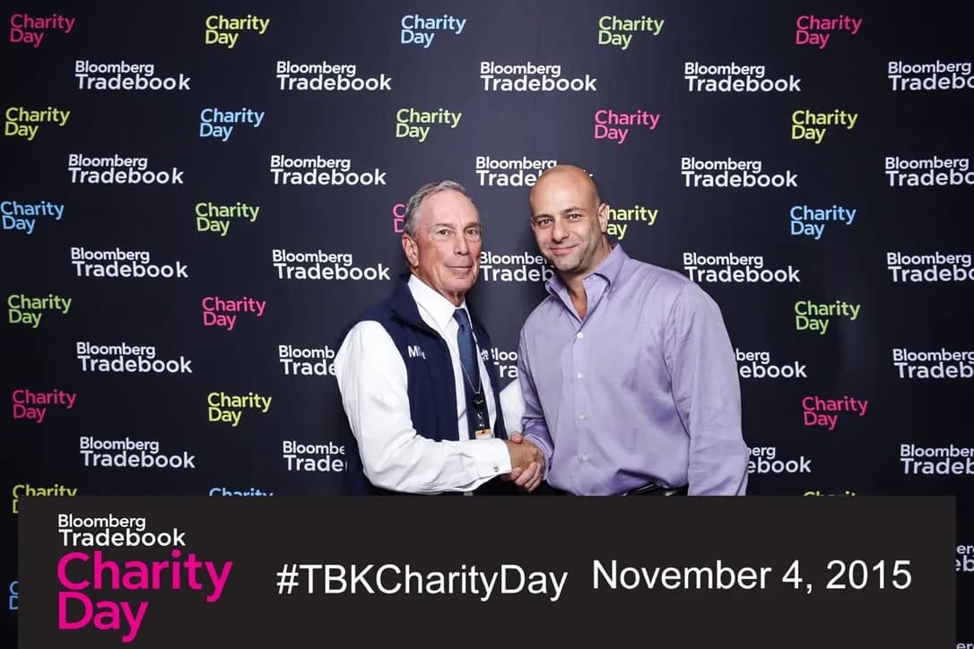 Shiran Nicholson shaking hands with the former mayor of New York City at a Wall Street trading-floor charity day in November 2015