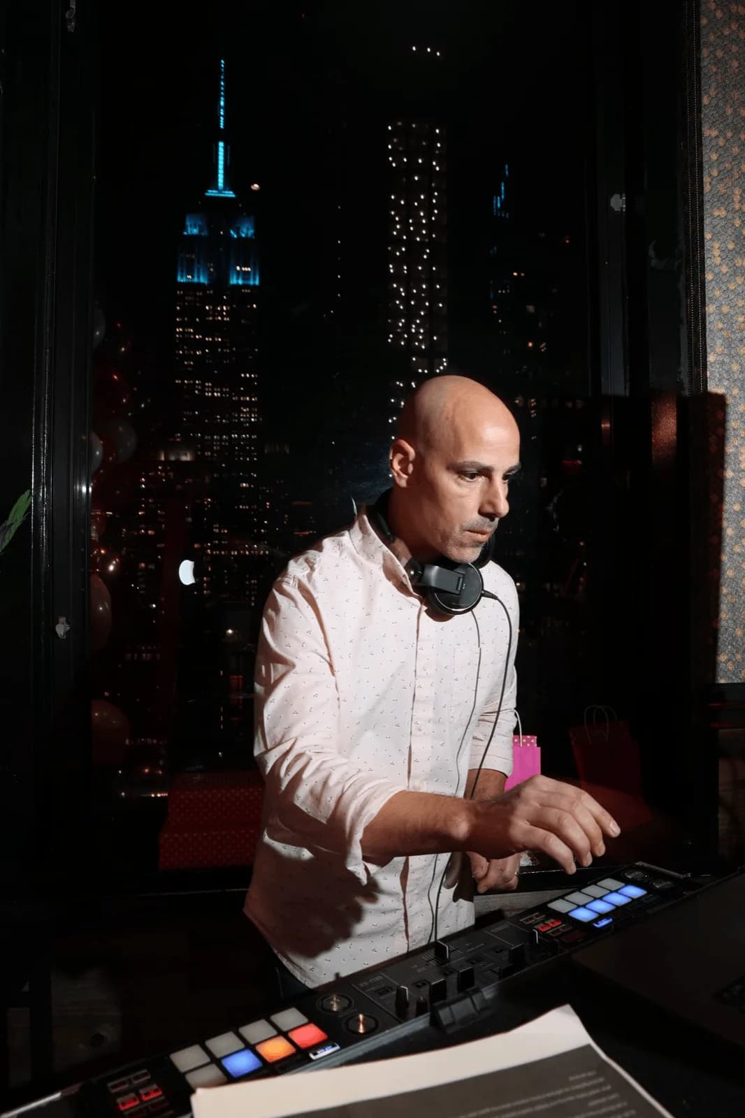 DJ Tommy at the decks with the New York City skyline as a backdrop