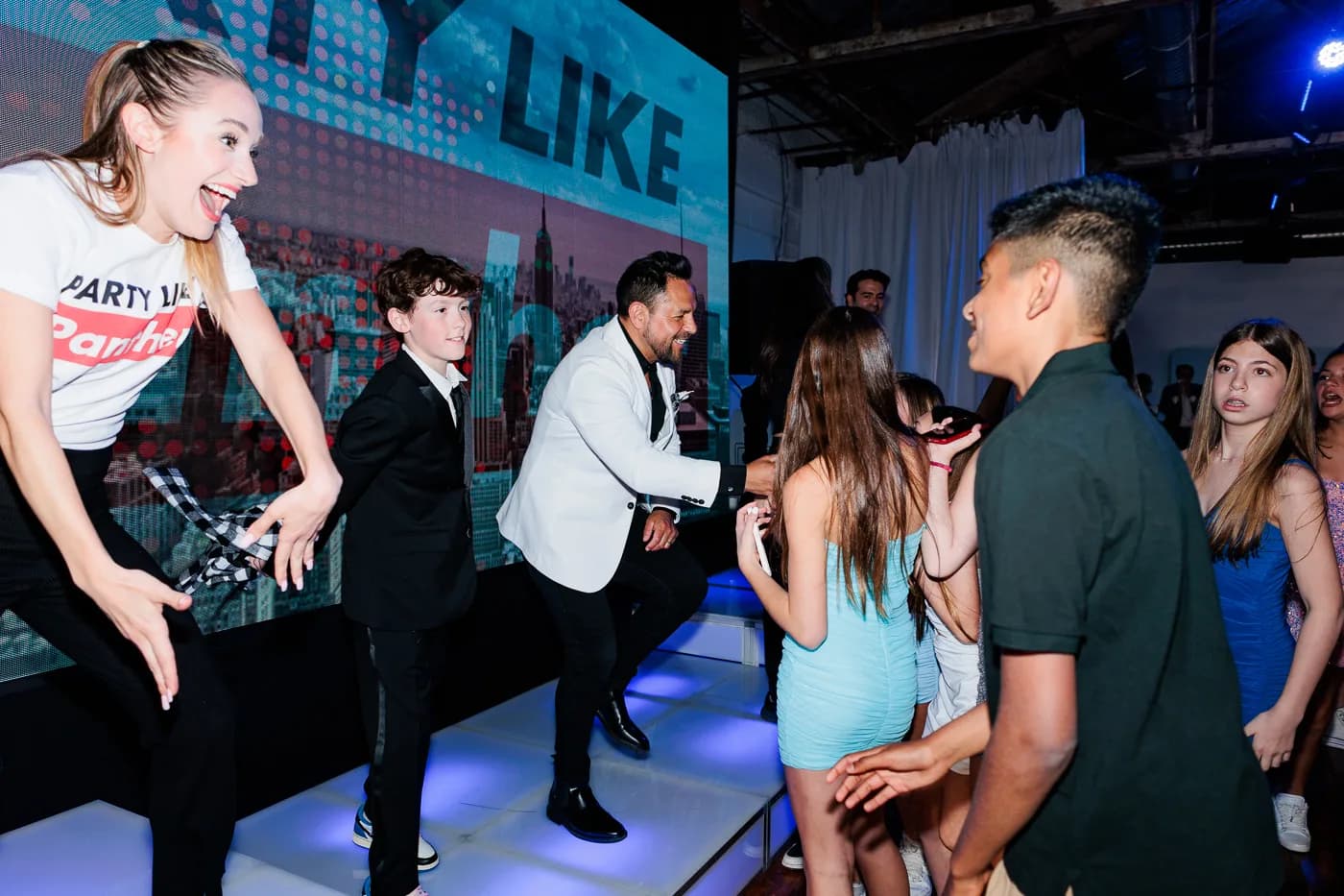 MC Nelson working the dance floor with a group of kids and dancers at a bar mitzvah, LED wall backdrop