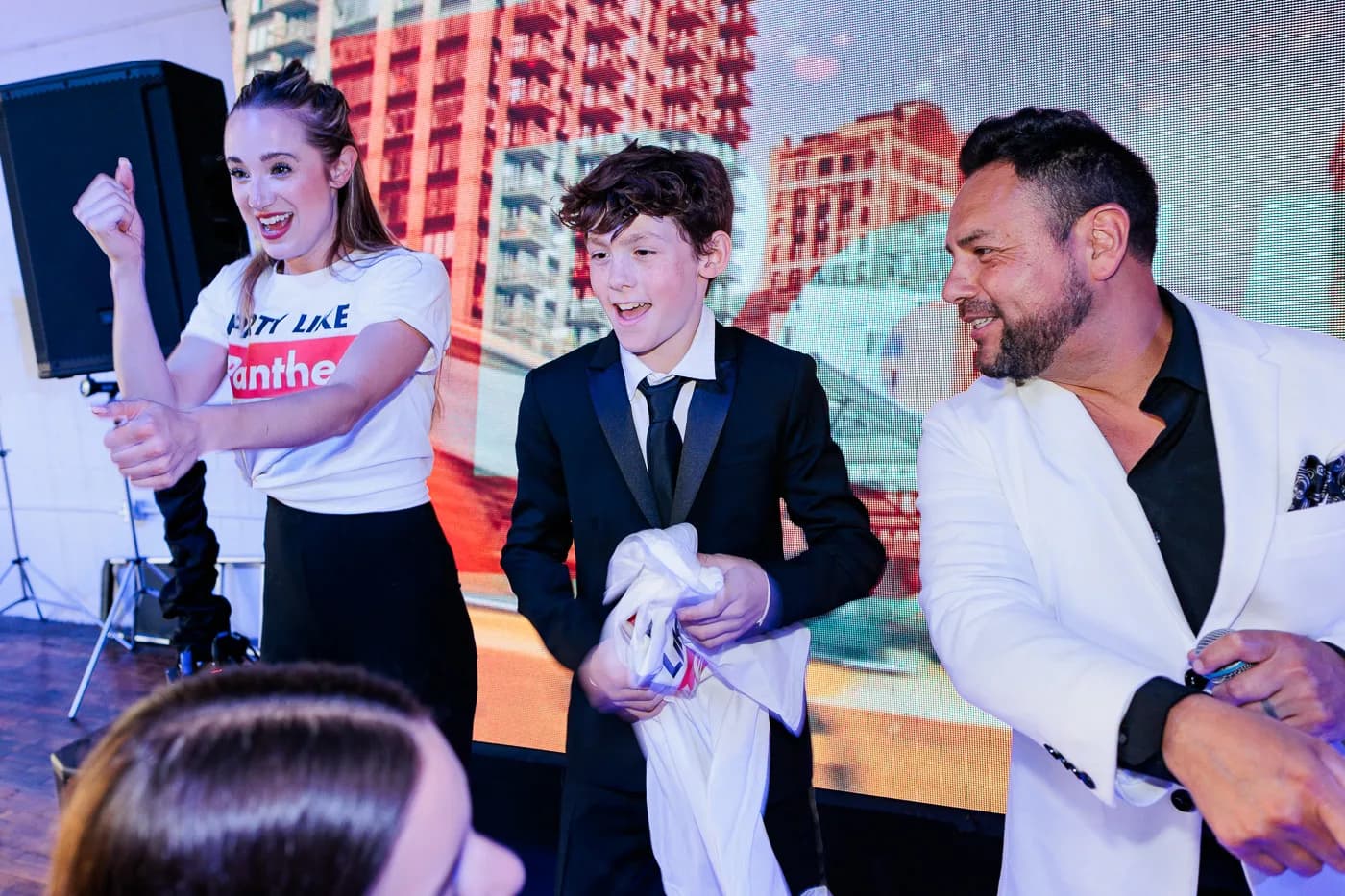 MC Nelson and a dancer celebrating with the bar mitzvah boy on stage at an upscale mitzvah event