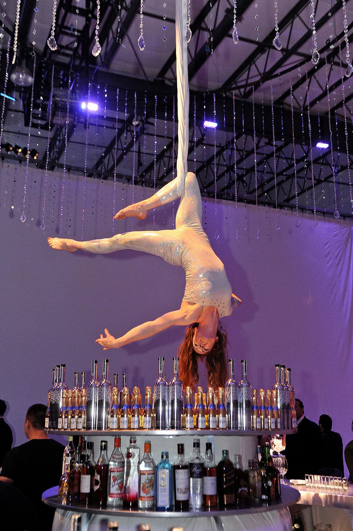 Aerial silk performer suspended above a luxury event floor