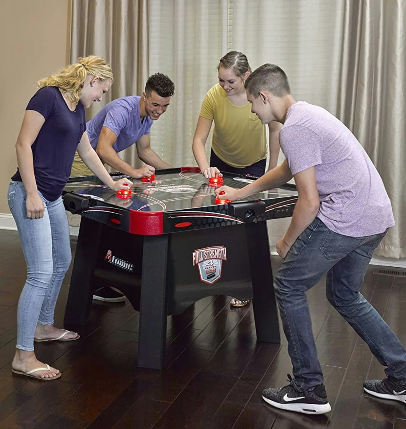 Four-way air hockey table at a bar mitzvah party in NYC, four players competing simultaneously on one oversized table