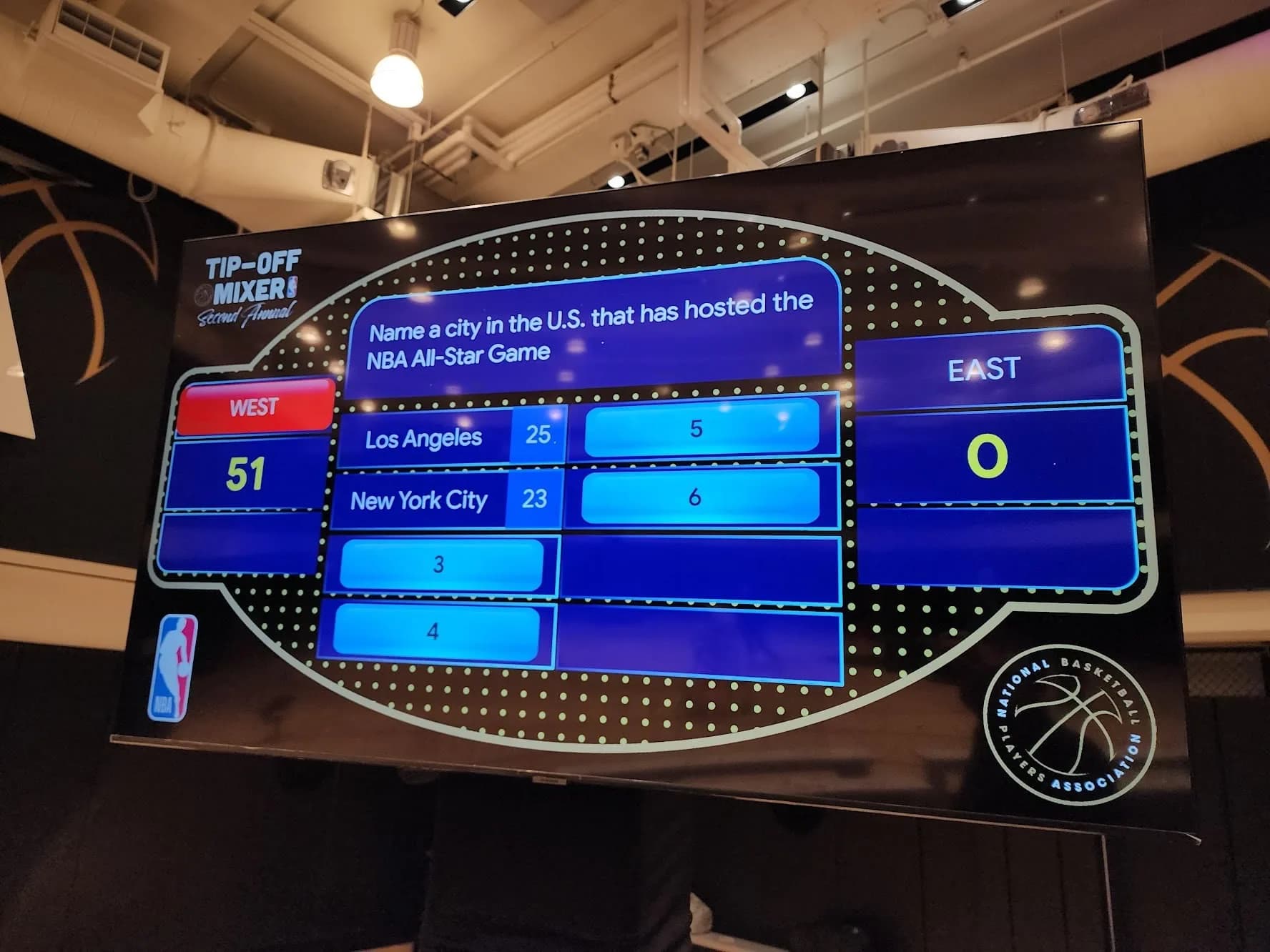 Guests competing in a live team trivia game show at a corporate event in Connecticut, teams buzzing in to answer questions